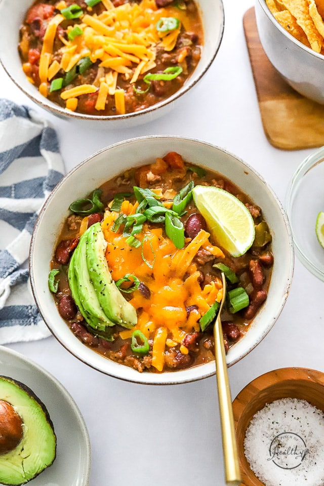 Instant Pot chili in a bowl with spoon and garnishes