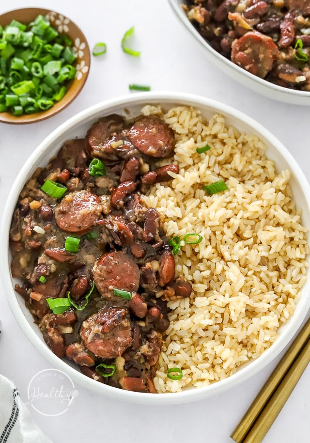 Red beans and rice in a white bowl sprinkled with green onion
