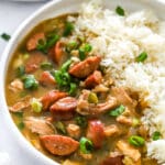 Chicken and sausage gumbo closeup in a white bowl with rice