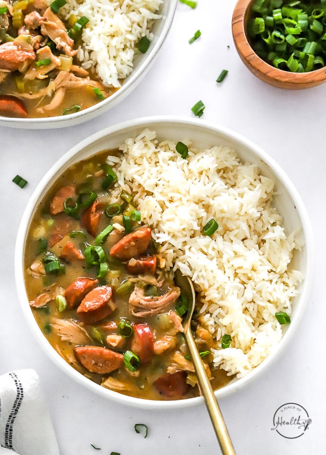 Finished styled chicken and sausage gumbo in white bowl with rice