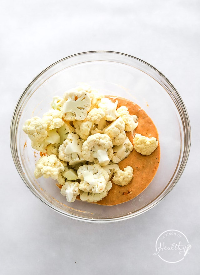 Cauliflower and wet batter in a glass bowl