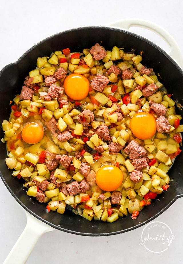 corned beef hash with cracked raw egg on it