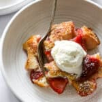 Strawberry Cobbler in a bowl with spoon and ice cream