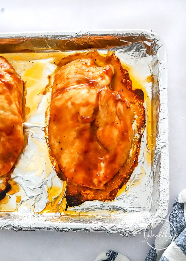cooked BBQ chicken breast on a baking sheet