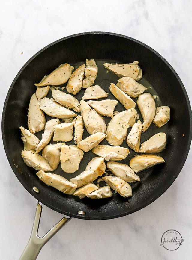 cooking sliced chicken in a pan