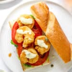 Shrimp Po' Boy with tartar sauce on a white plate, open faced