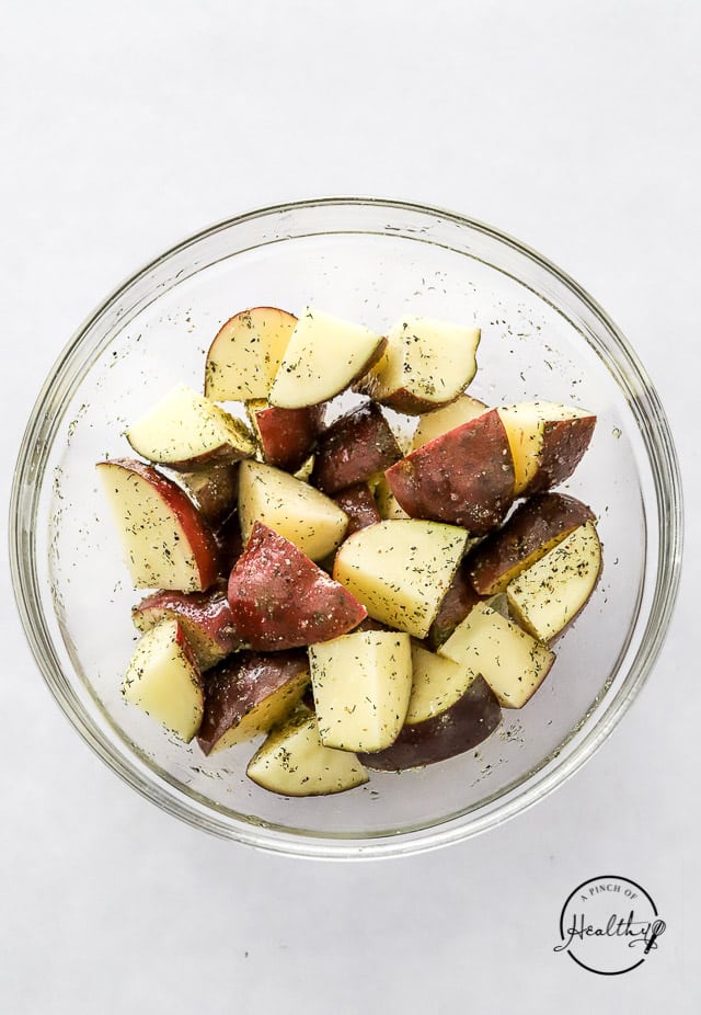 tossing potatoes in seasoning