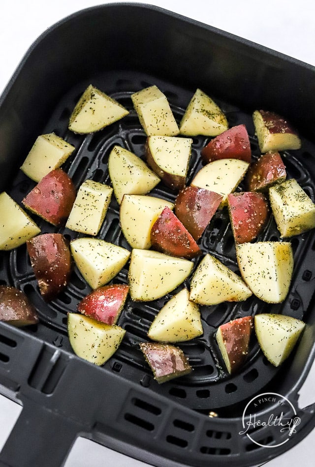 adding raw seasoned red potatoes to fryer basket