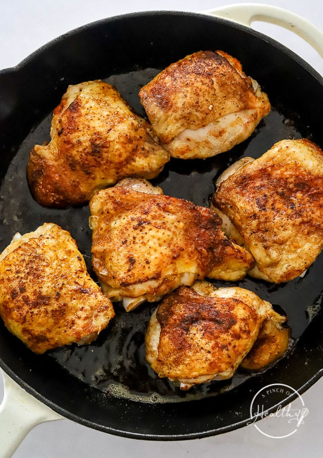 chicken thighs cooking in a pan