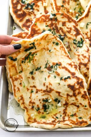 hand grabbing a garlic naan