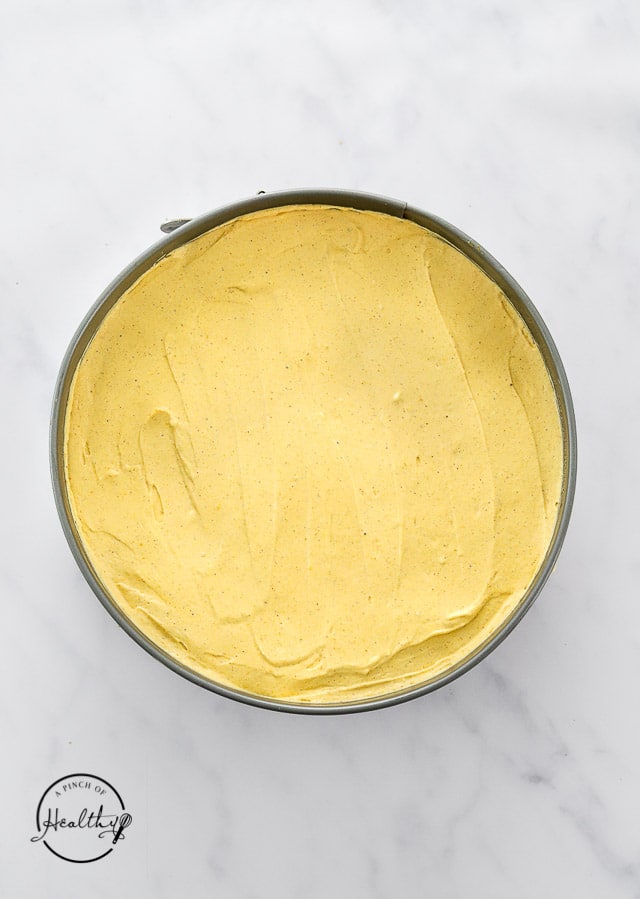 assembling no bake pumpkin cheesecake in a springform pan