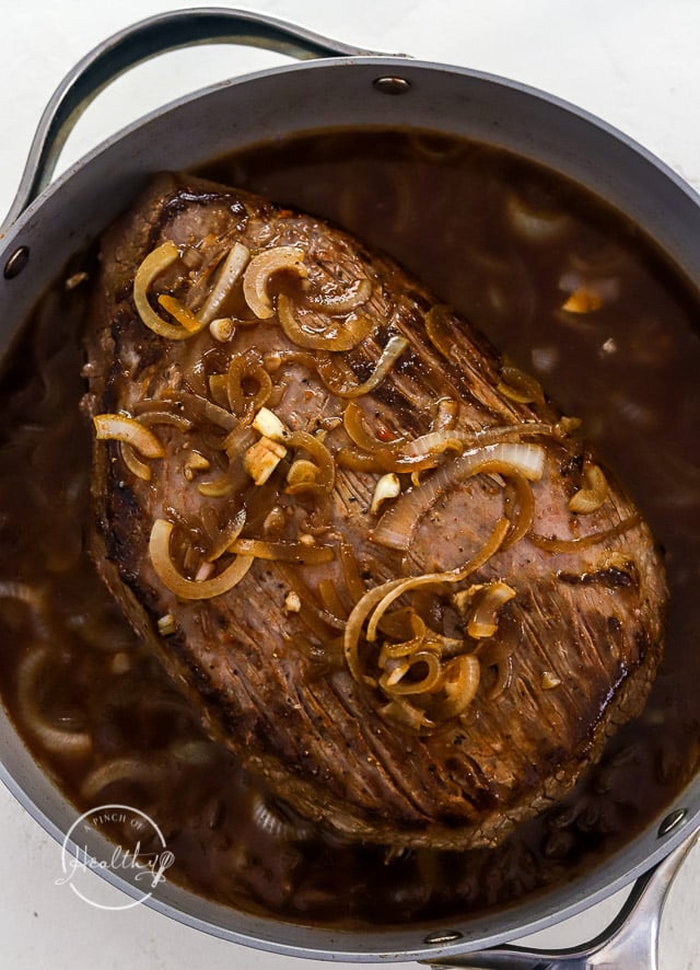 Beef brisket nestled in the sauce before baking