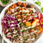 Mediterranean Bowl with dressing in white bowl with gold spoon