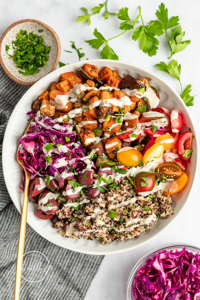 Vegan Mediterranean bowl with gold spoon and scattered parsley