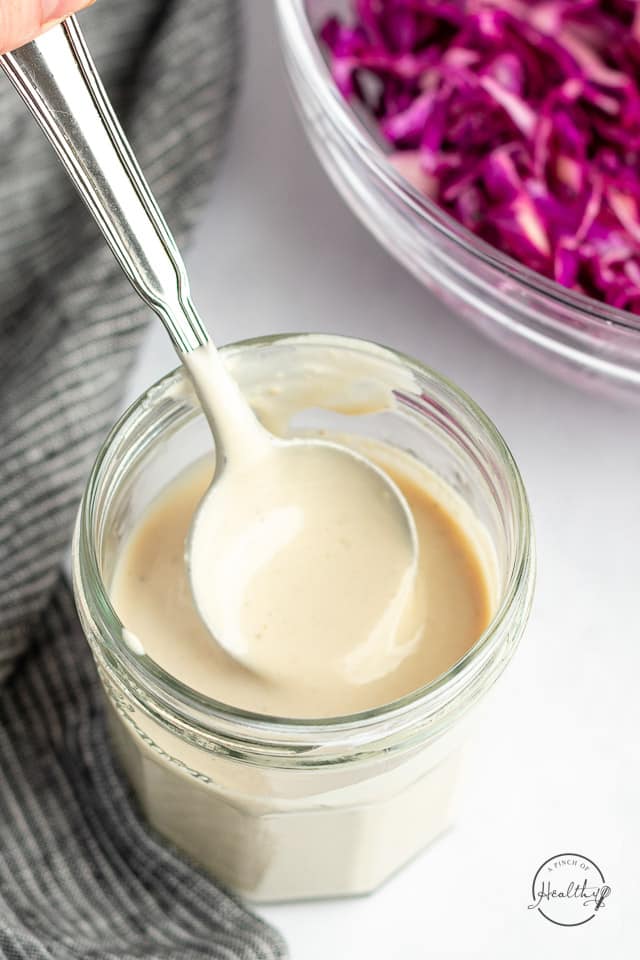 tahini sauce in a jar with spoon