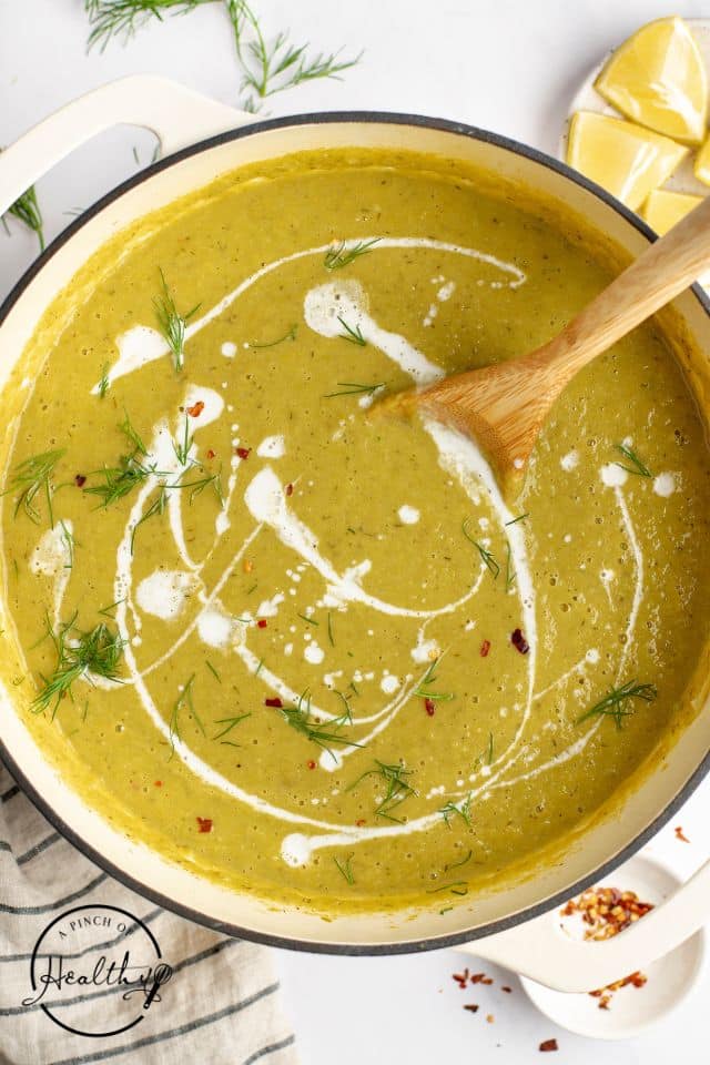 asparagus soup in a Dutch oven with a wooden spoon in the pot