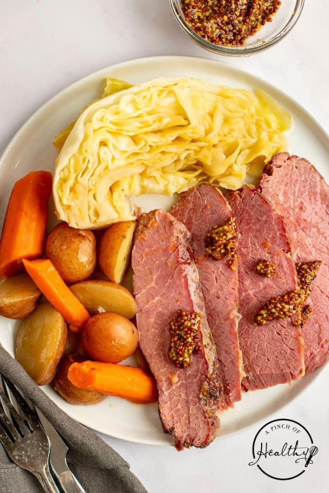 a serving of corned beef and cabbage with Dijon mustard on top