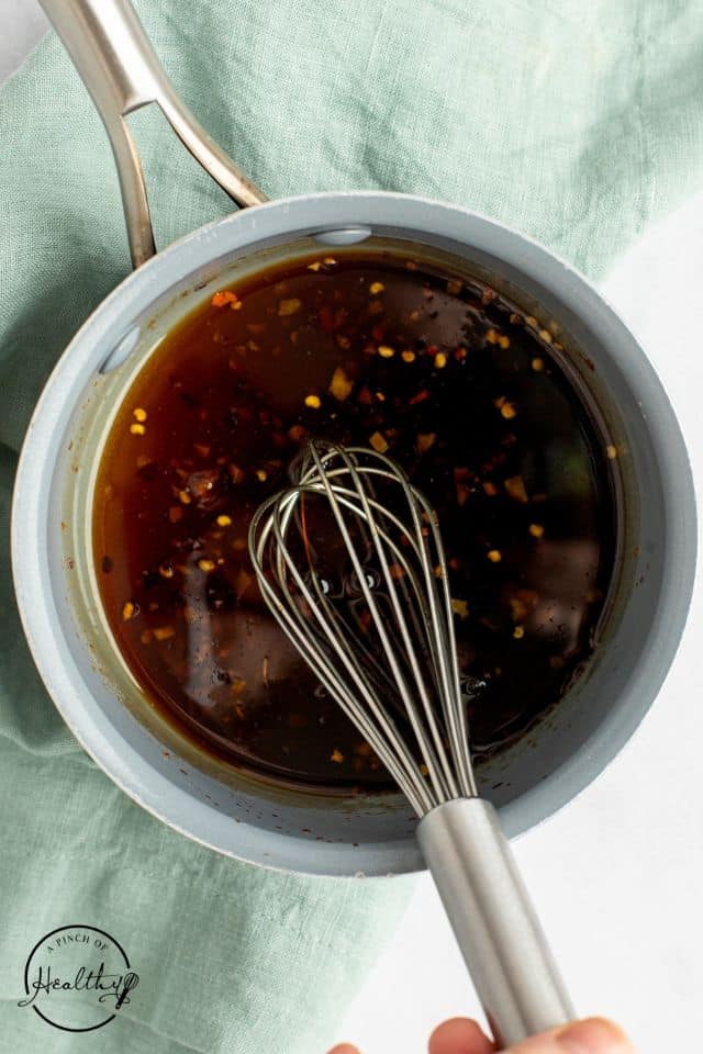 Glaze ingredients in a white bowl with a whisk inside.