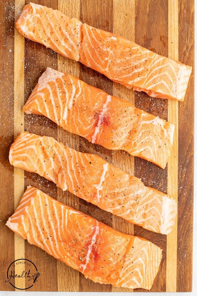 seasoned salmon on a wooden cutting board shot from overhead