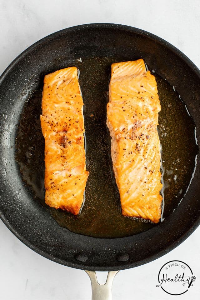 seasoned salmon in a cast iron skillet shot from overhead