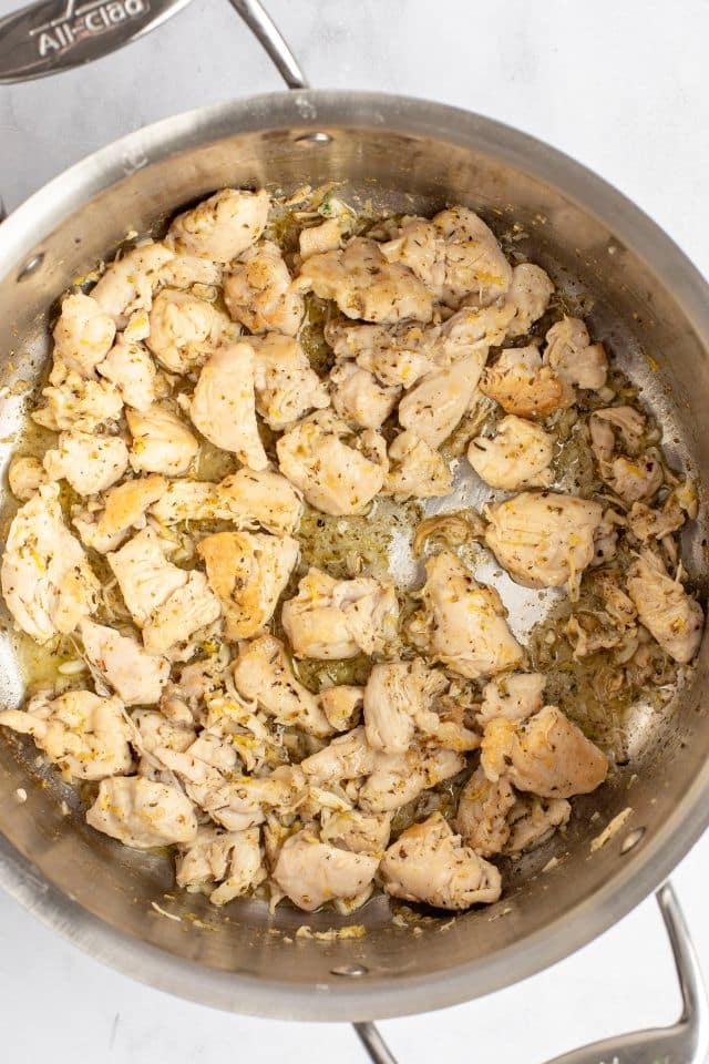 chicken cooked in a large metal skillet and slightly browned.