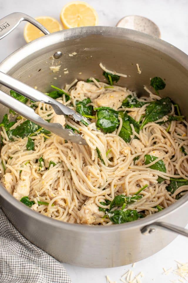 lemon chicken pasta with tongs used to stir it.