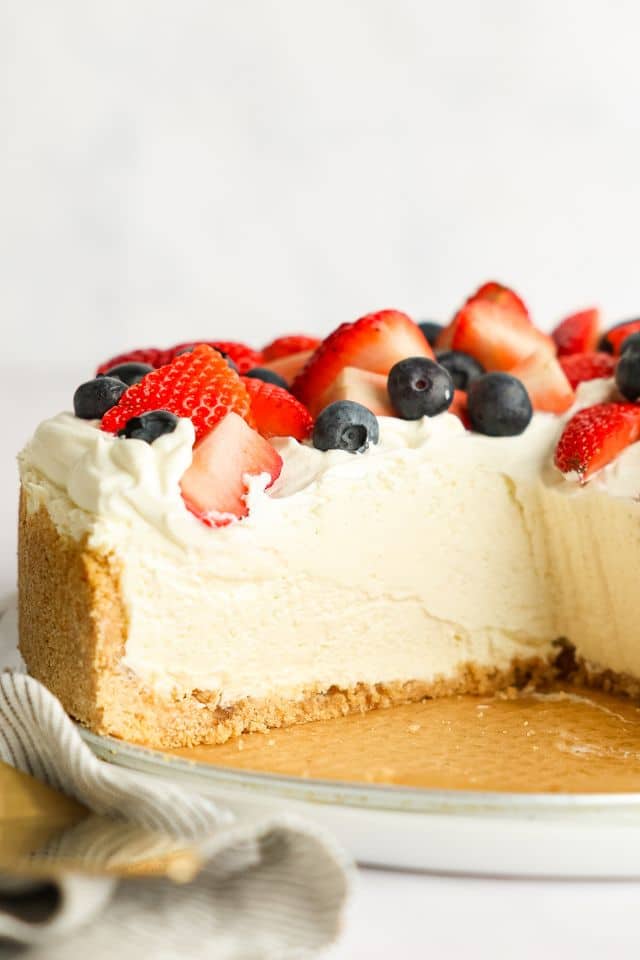 No bake cheesecake with a slice removed to show to smooth creamy texture.