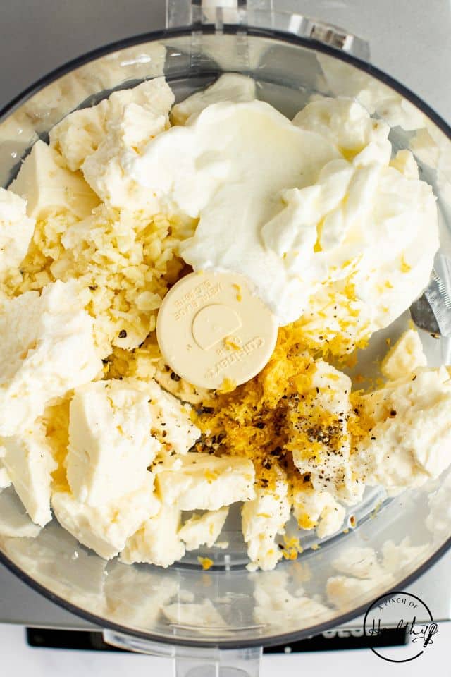 Feta, seasonings, and yogurt in a food processor before being blended.