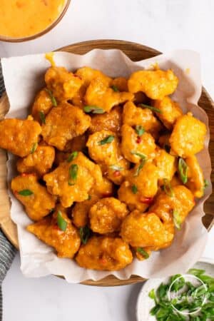 Bang Bang Chicken on a wooden platter on parchment paper.