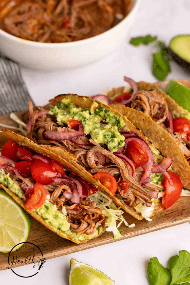 Beef brisket tacos on a wooden platter.