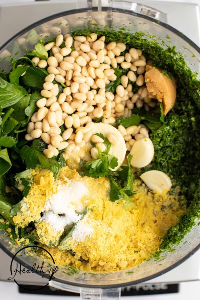 All ingredients for kale pesto except the oil added to the food processor before being processed.