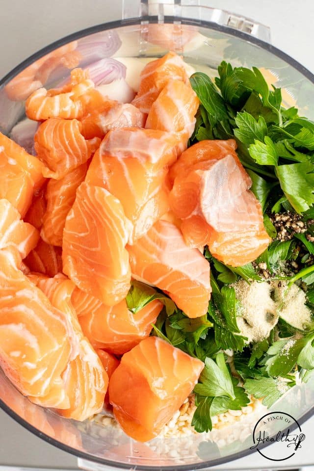 Salmon added to the food processor before pulsing.