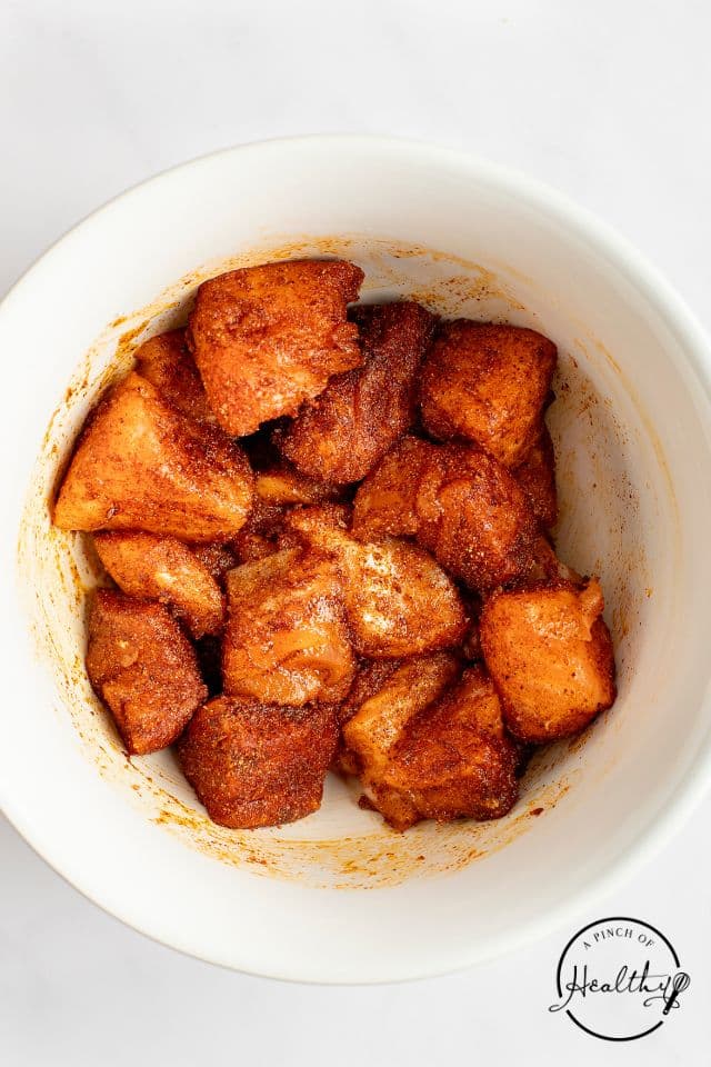 Salmon after being tossed in oil and the seasoning blend.