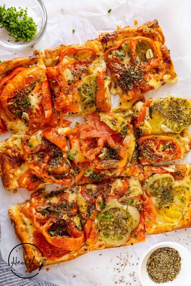 Cut tomato tart after being baked on a white background.