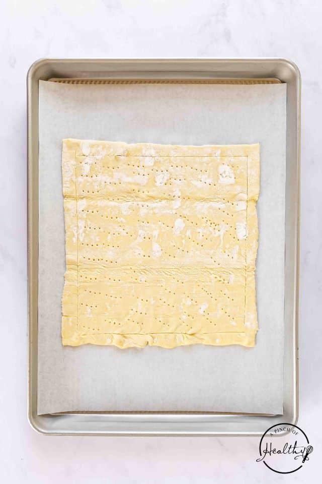 Puff pastry placed on a baking sheet covered with parchment.