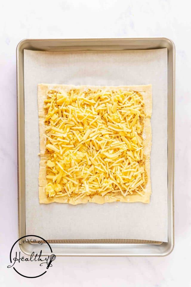 Shredded cheeses sprinkled all over the top of the Dijon mustard topped puff pastry.