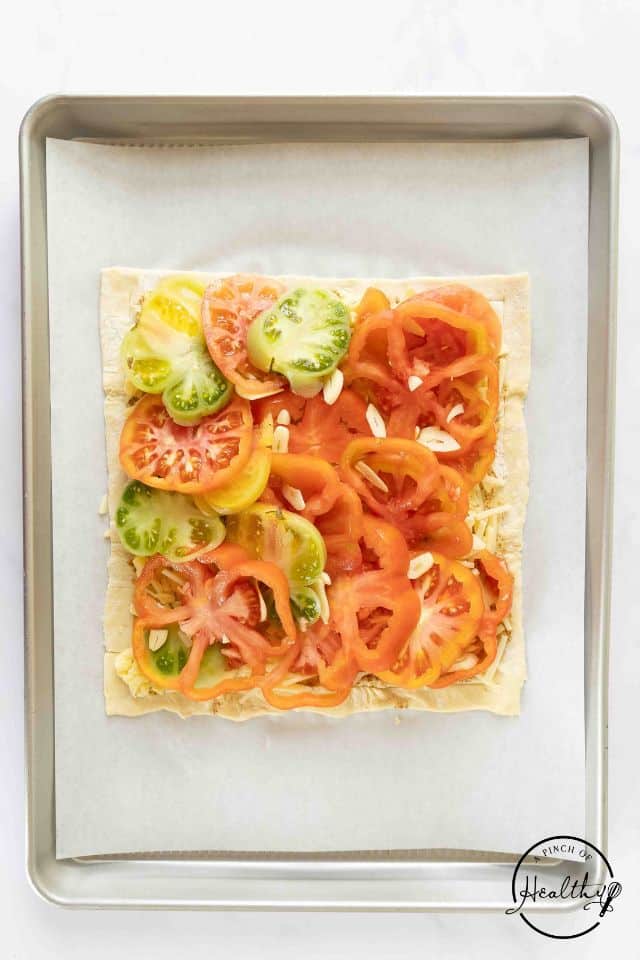 Fresh tomatoes and garlic on top of the cheese-covered puff pastry.