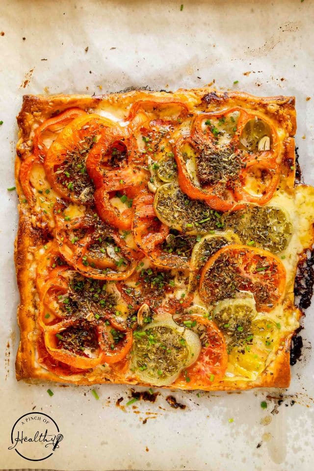 Cooked tomato tart on the baking sheet before being sliced.