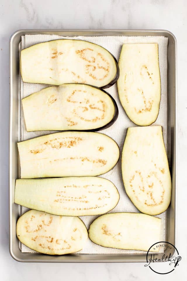 Eggplant slices laid out on a baking sheet.