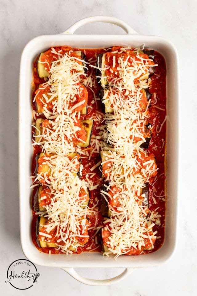 Cheese topped rollatinis in a large white baking dish.