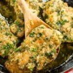 Garlic butter chicken in a large skillet with a wooden spoon.