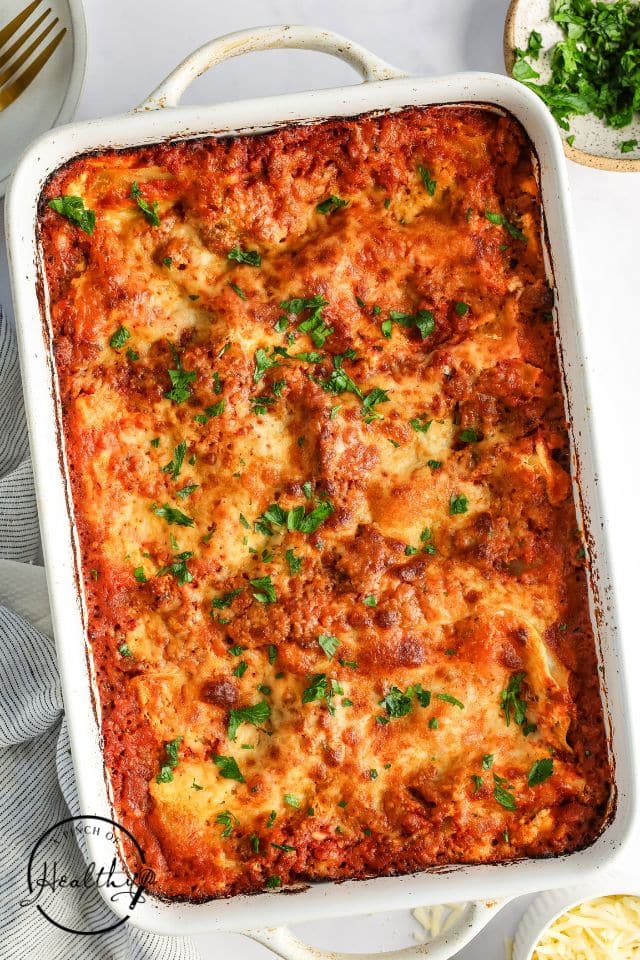 Baked homemade lasagna in a large white baking dish.
