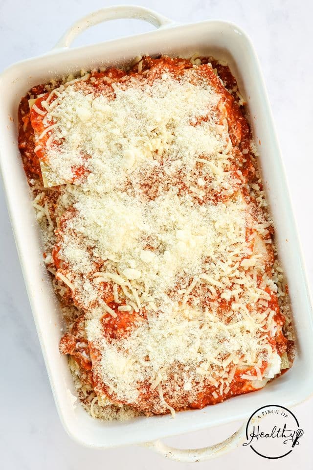 A pan of homemade lasagna in a large rectangular baking dish before being baked in the oven.