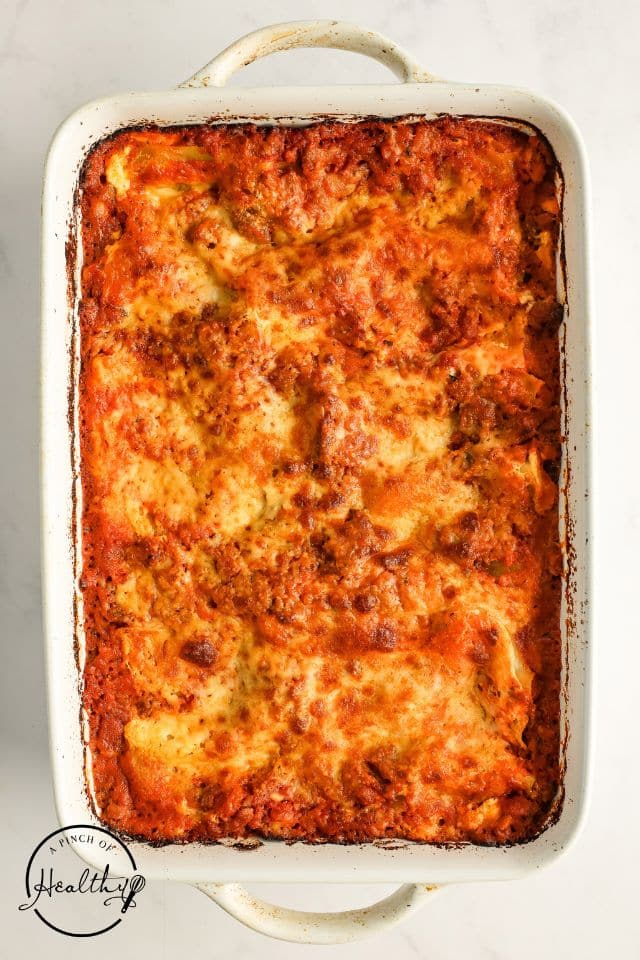 Homemade lasagna after being baked in a large rectangular baking dish.
