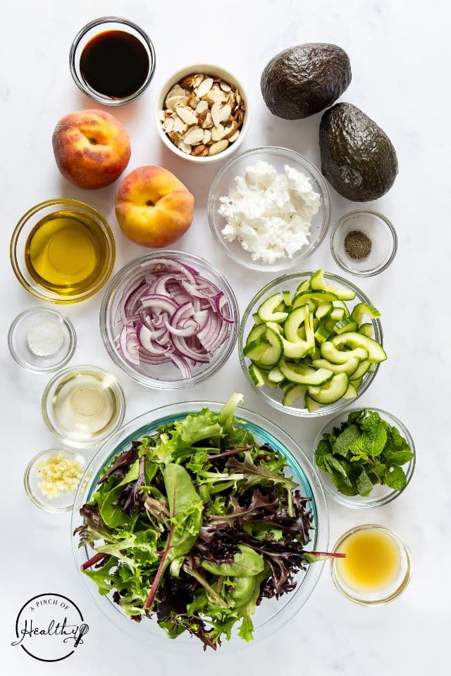 Ingredients for peach salad on a white background in separate containers.