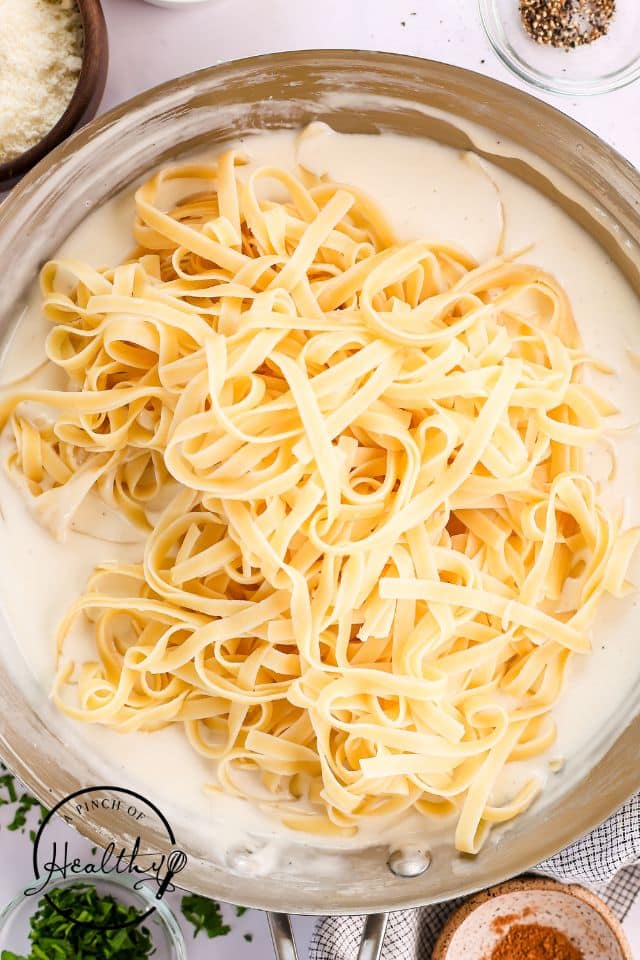 Pasta placed in the alfredo sauce after being cooked.