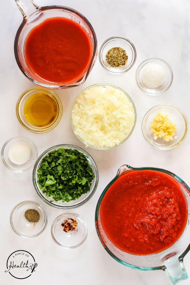 Ingredients for homemade meatballs in separate containers on a white background.