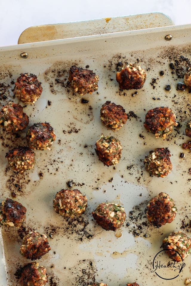 Cooked meatballs on a baking sheet.