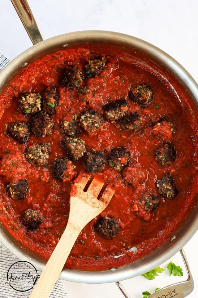 Meatballs in the sauce after being simmered together.