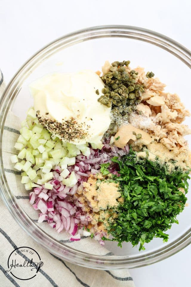 Ingredients for salmon salad in a glass bowl before being mixed together.